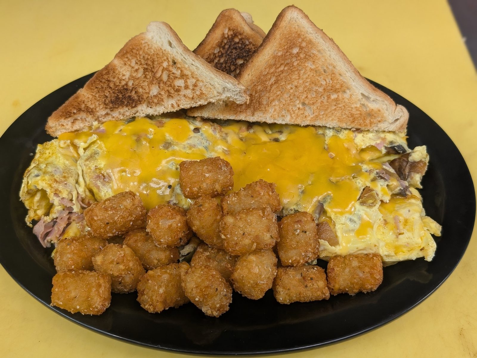 Cheese omelette platter with tots and toast at Sak's Deli